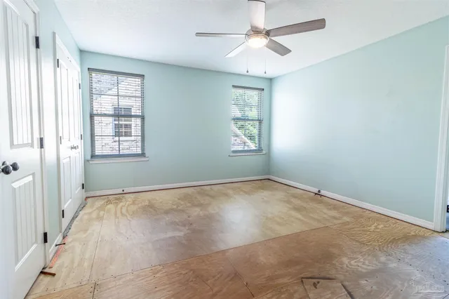 an empty room with closet and a ceiling fan