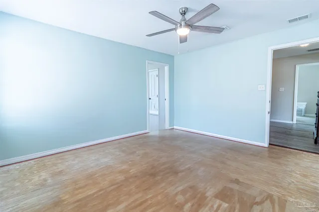 an empty room with fan and a ceiling fan