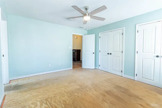 an empty room with fan and windows