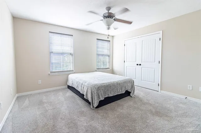 a bedroom with a bed and a ceiling fan