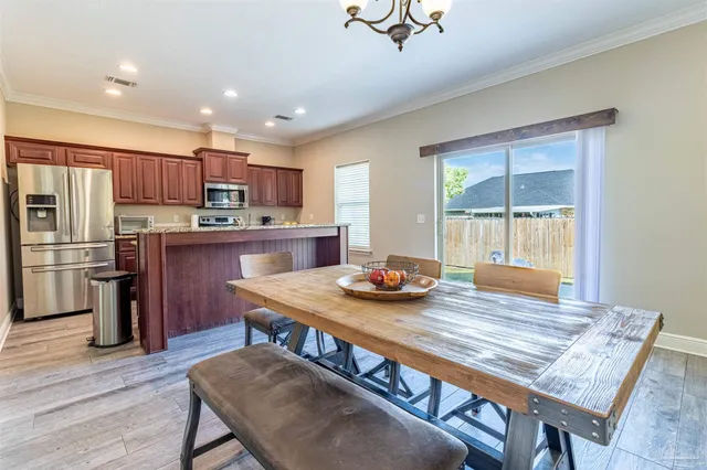 a kitchen with kitchen island granite countertop wooden floors stainless steel appliances a sink and a window