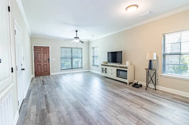 a view of an empty room with window and wooden floor