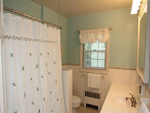 1031 Harvey Street Raleigh, NC 27608 - Photo 8 of 12 a bathroom with a shower curtain and a window