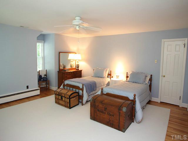 1031 Harvey Street Raleigh, NC 27608 - Photo 9 of 12 a bedroom with a bed and a chandelier