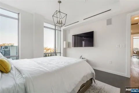 a bedroom with a bed window and a flat screen tv