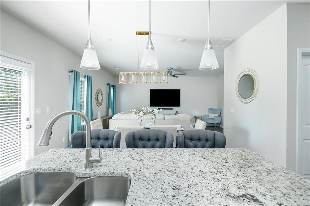 2288 Elsie Way Hampton, GA 30228 - Photo 14 of 45 a kitchen with kitchen island granite countertop a sink a stove and a chandelier