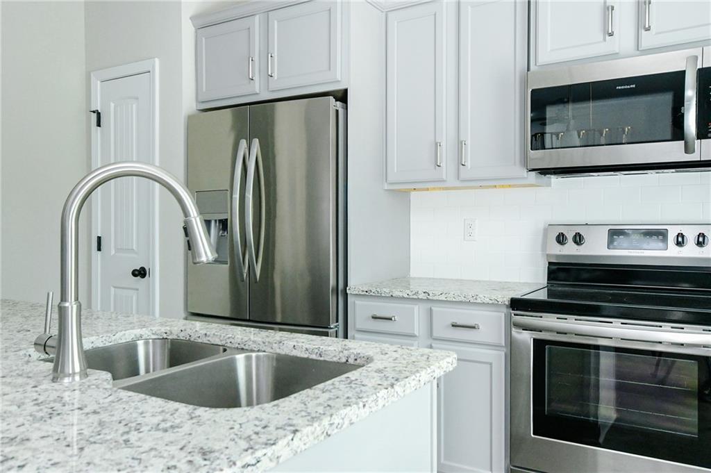 2288 Elsie Way Hampton, GA 30228 - Photo 15 of 45 a kitchen with stainless steel appliances granite countertop a stove microwave and refrigerator