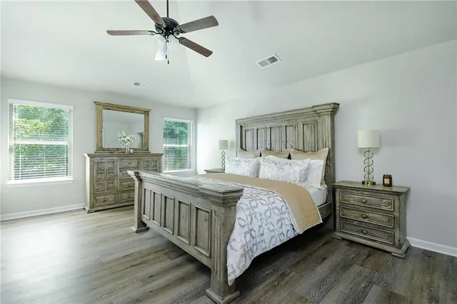 a bedroom with a bed and a flat tv screen on dresser