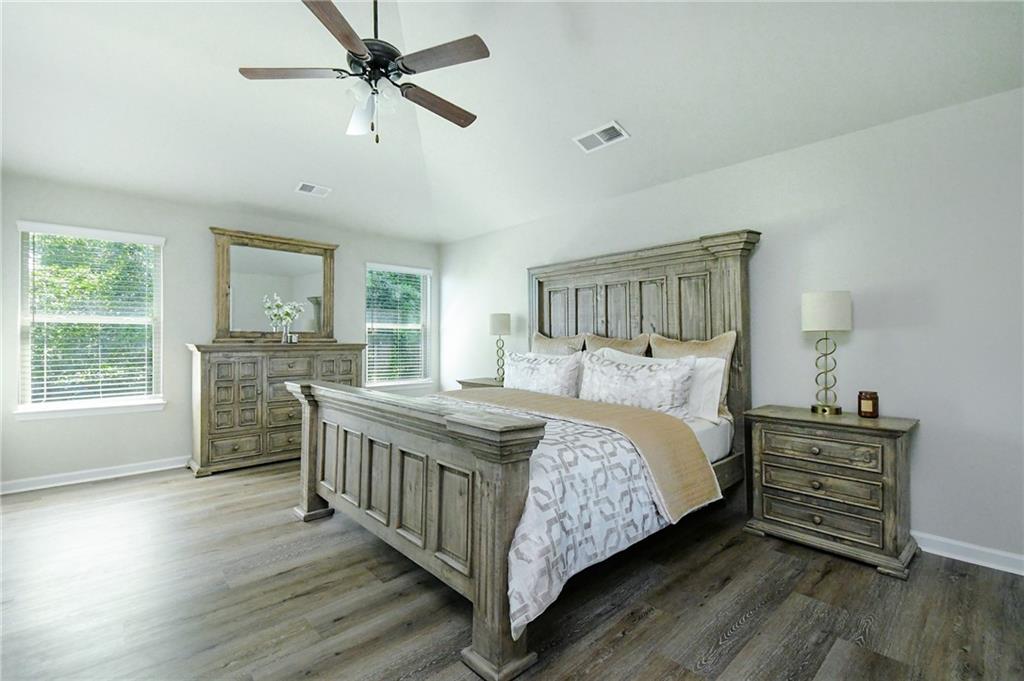 2288 Elsie Way Hampton, GA 30228 - Photo 22 of 45 a bedroom with a bed a dresser and windows