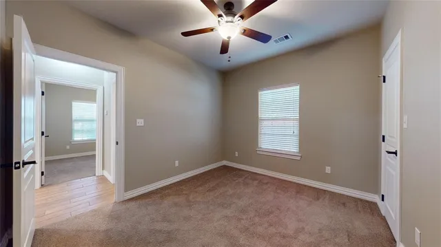 an empty room with fan and windows