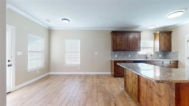 a kitchen with granite countertop a sink and wooden floor