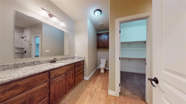 a spacious bathroom with a granite countertop sink mirror and toilet