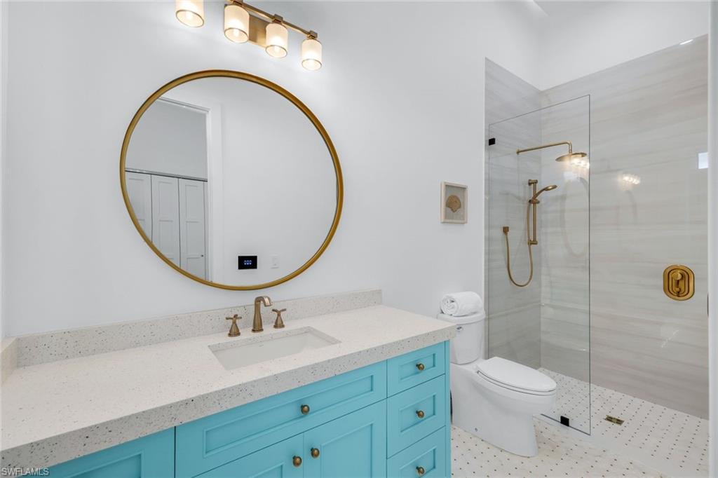6677 Hunters Road Naples, FL 34109 - Photo 27 of 50 a bathroom with a toilet a sink a mirror and shower