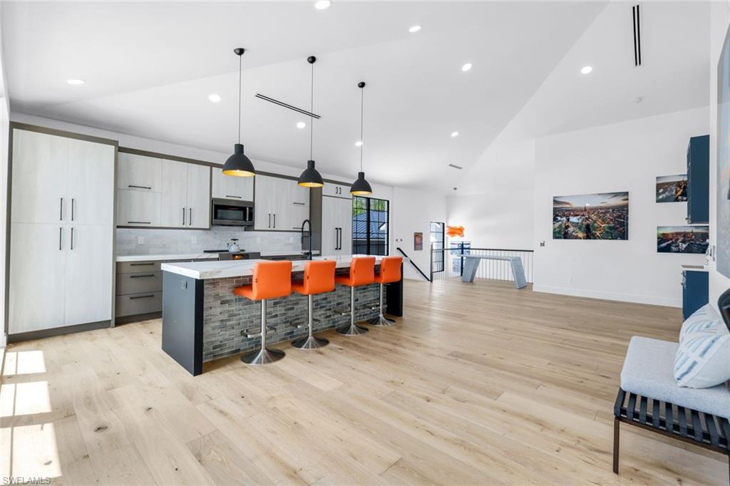 6677 Hunters Road Naples, FL 34109 - Photo 33 of 50 a large kitchen with stainless steel appliances kitchen island granite countertop a large center island and a stove top oven