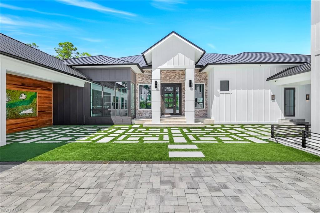 6677 Hunters Road Naples, FL 34109 - Photo 6 of 50 a front view of a house with a garden