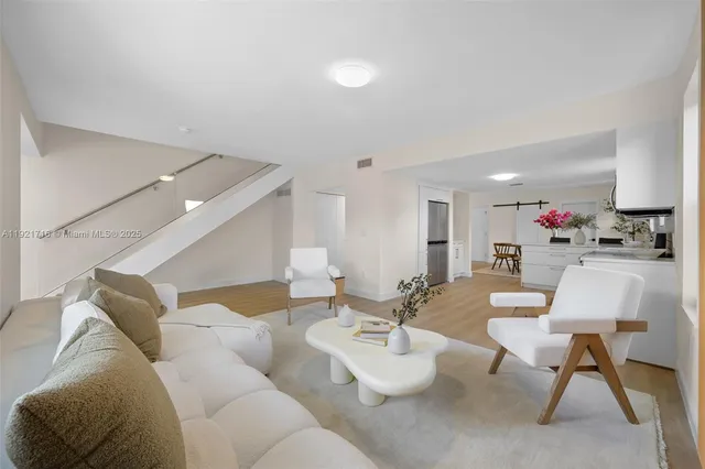 a living room with furniture and a dining table with chairs