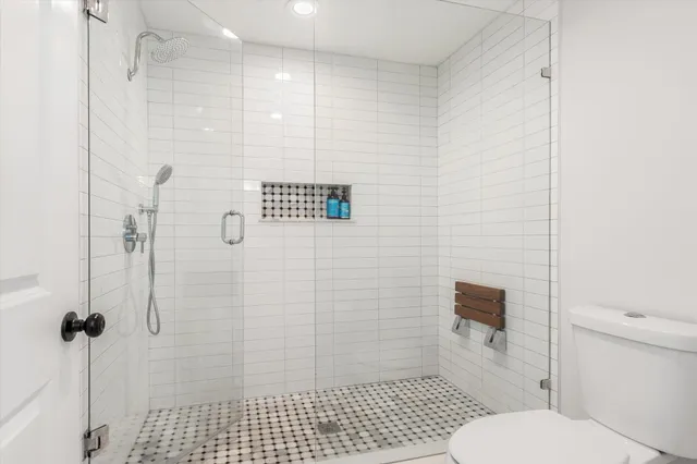 a bathroom with a toilet and a shower
