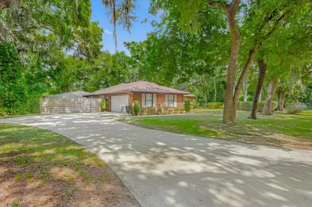 a front view of a house with yard and green space