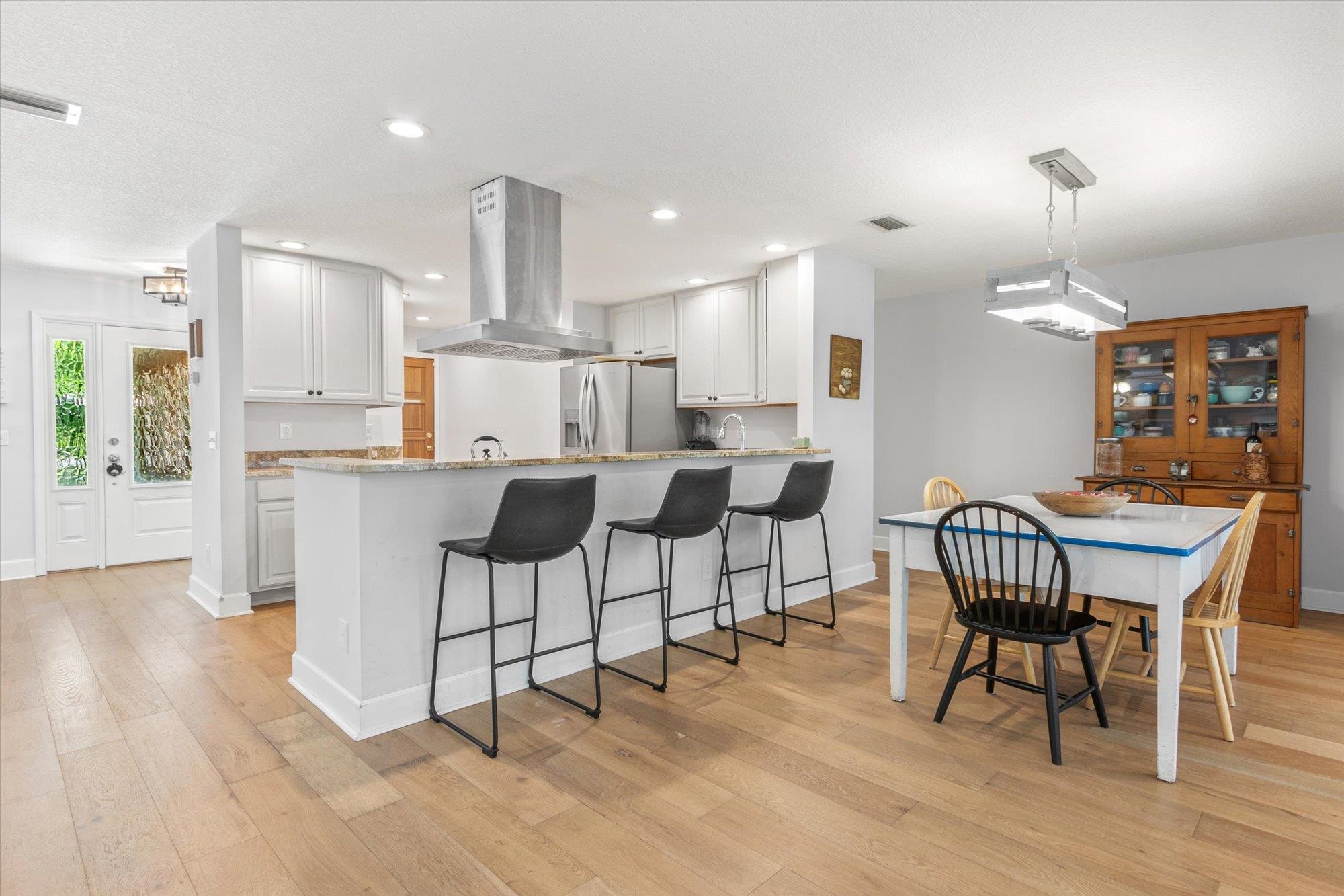 200 Raintree Trail St. Augustine, FL 32086 - Photo 5 of 36 a dining room with kitchen island stainless steel appliances furniture a dining table and chairs with wooden floor