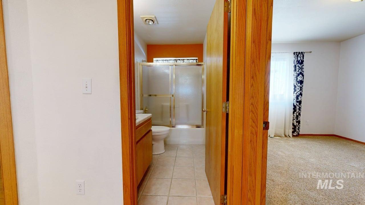 2794 9th Avenue Clarkston, WA 99403 - Photo 18 of 34 Full bath with vanity, enclosed tub / shower combo, light carpet, and light tile patterned flooring
