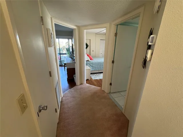 a view of a hallway with wooden floor and a bathroom