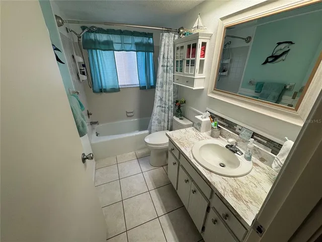 a bathroom with a granite countertop sink a toilet and shower