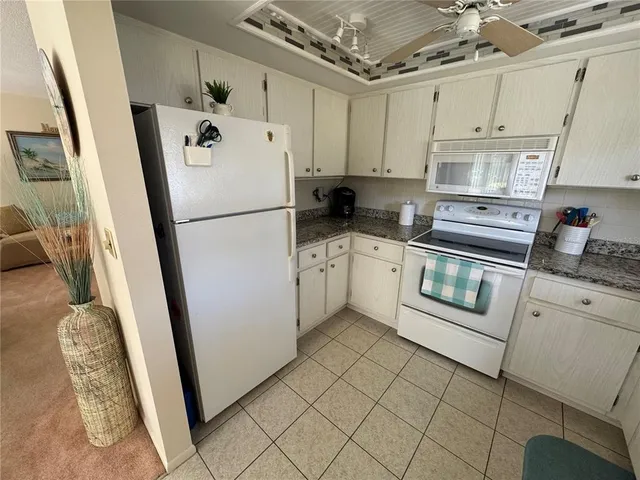 a white refrigerator freezer sitting inside of a kitchen