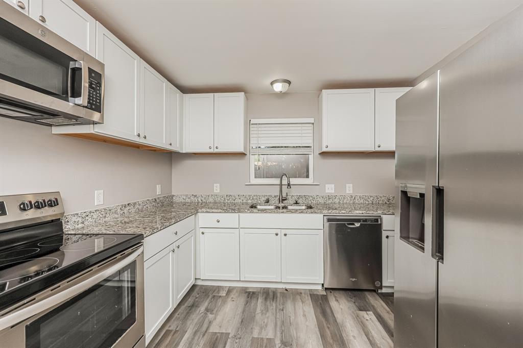 2155 Gaylord Drive Dallas, TX 75227 - Photo 11 of 21 a kitchen with stainless steel appliances granite countertop a sink stove and refrigerator