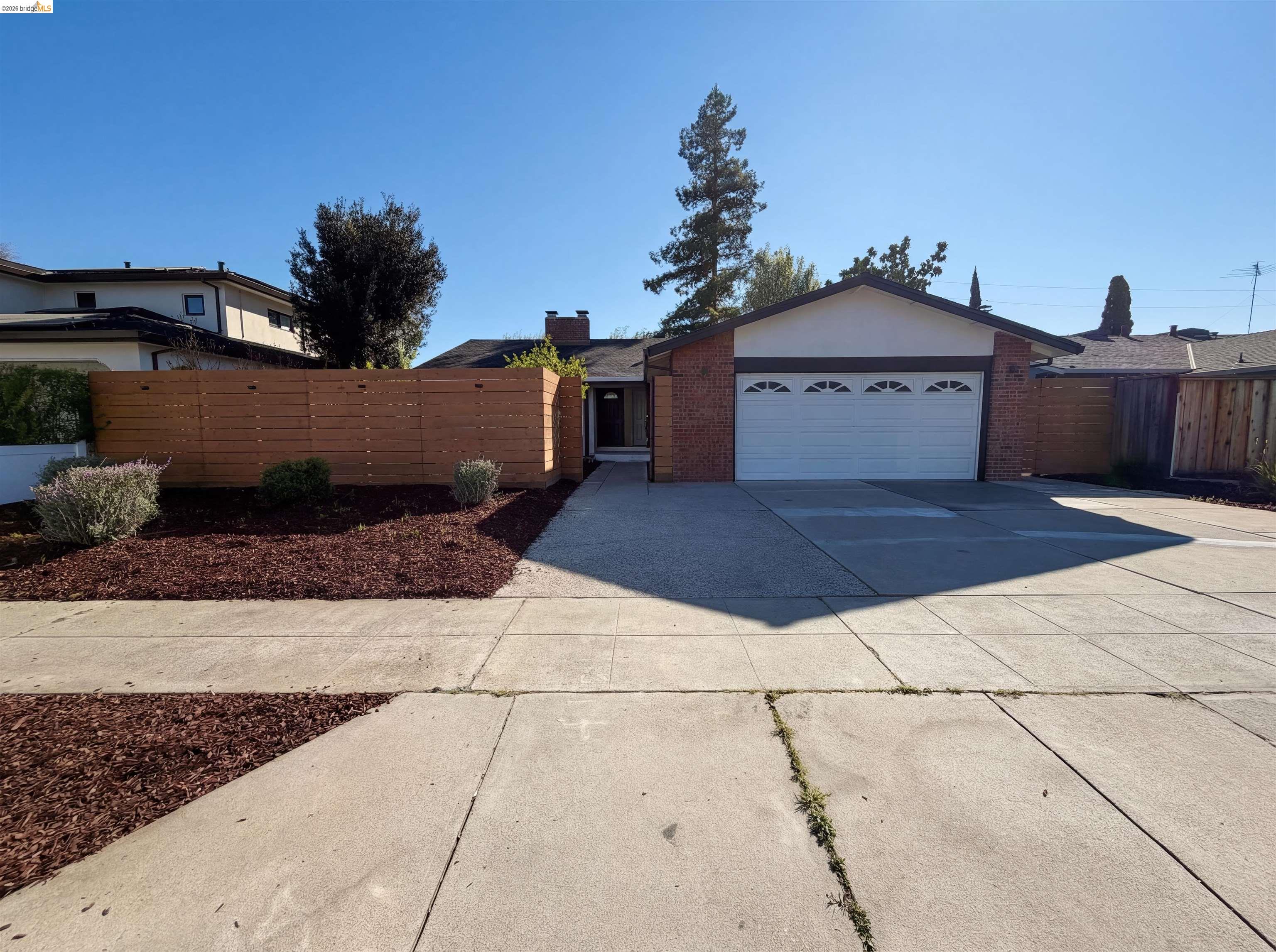 1564 South Wolfe Road Sunnyvale, CA 94087 - Photo 12 of 27 View of front of house featuring brick siding, an attached garage, driveway, and a chimney