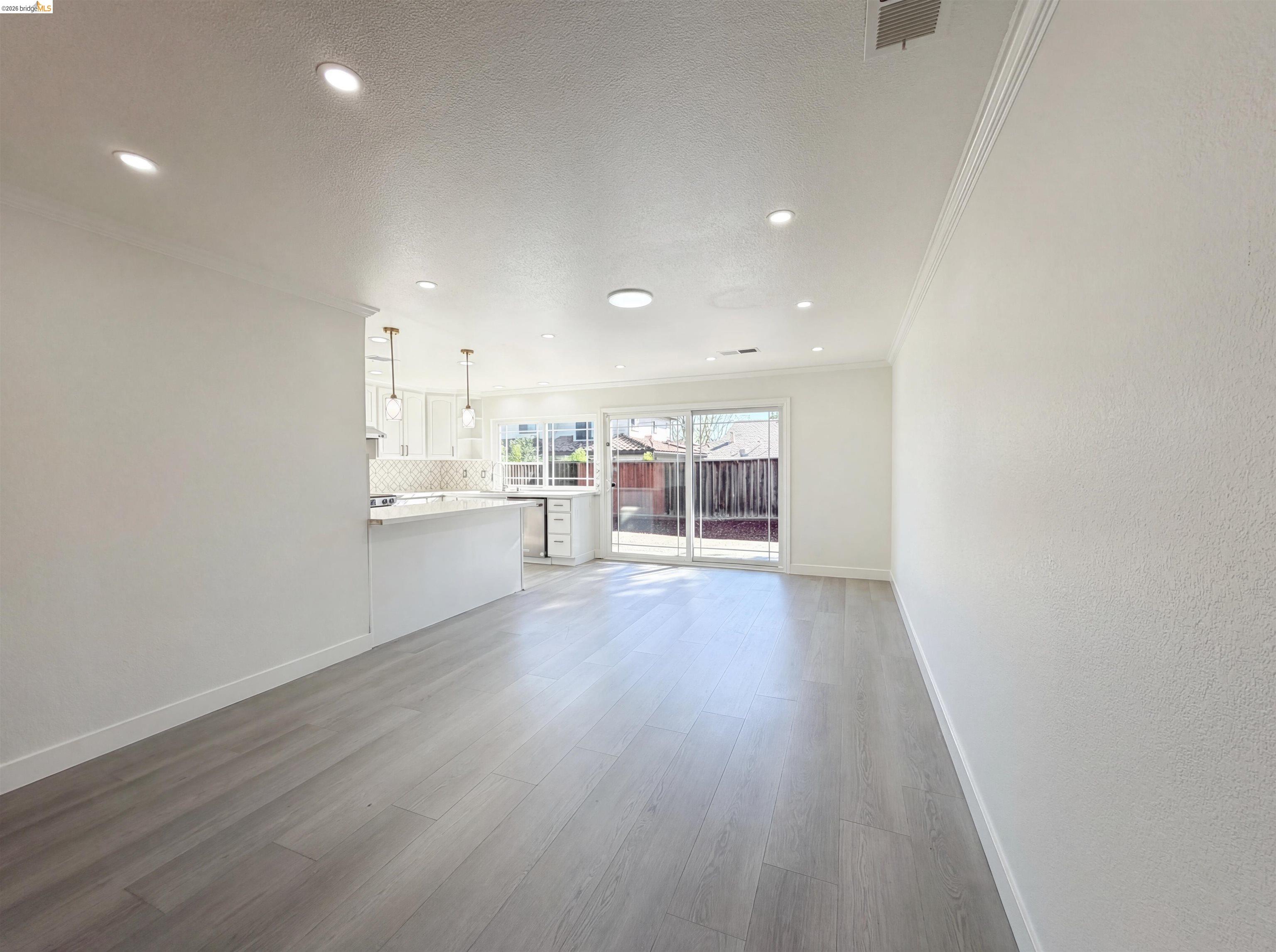 1564 South Wolfe Road Sunnyvale, CA 94087 - Photo 20 of 27 Unfurnished living room with crown molding, light wood-type flooring, recessed lighting, and a textured ceiling