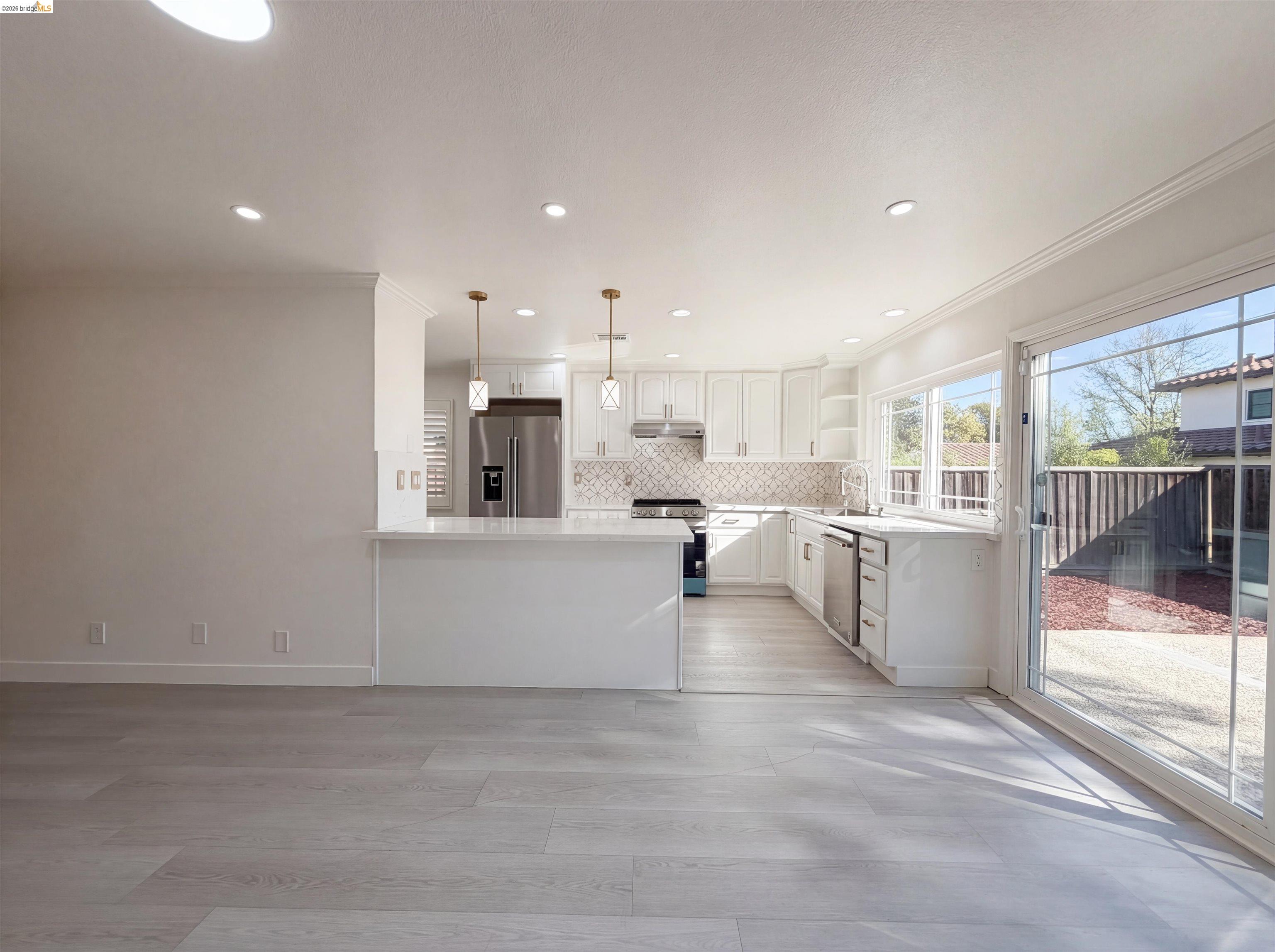 1564 South Wolfe Road Sunnyvale, CA 94087 - Photo 21 of 27 Kitchen with open shelves, stainless steel appliances, white cabinetry, a peninsula, and decorative light fixtures