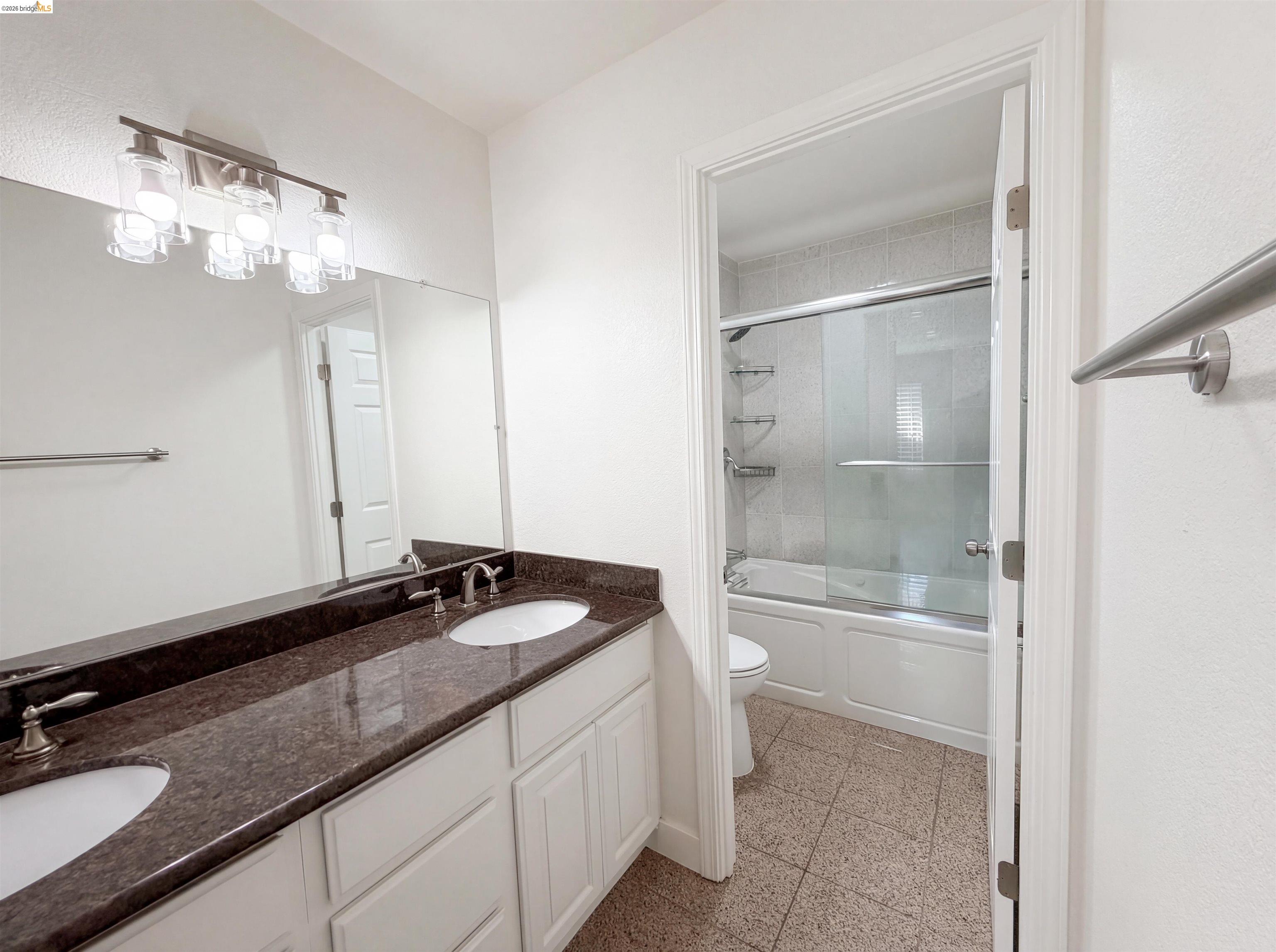 1564 South Wolfe Road Sunnyvale, CA 94087 - Photo 6 of 27 Full bathroom featuring double vanity, enclosed tub / shower combo, and granite tiled floors