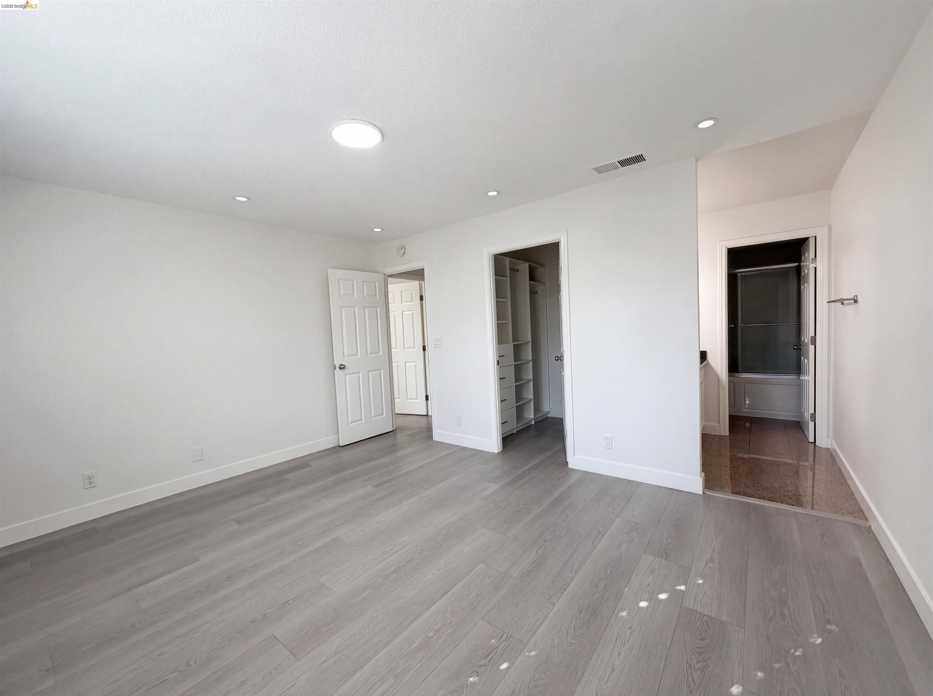 1564 South Wolfe Road Sunnyvale, CA 94087 - Photo 8 of 27 Unfurnished bedroom with a walk in closet, light wood-style flooring, ensuite bathroom, and recessed lighting