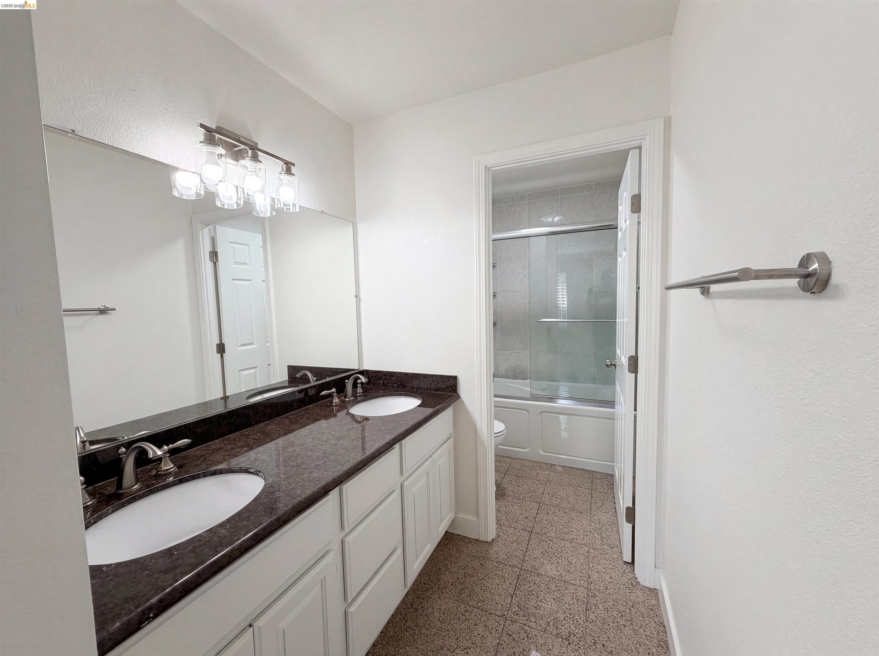 1564 South Wolfe Road Sunnyvale, CA 94087 - Photo 9 of 27 Bathroom with double vanity, granite tiled floors, and shower / bath combination with glass door