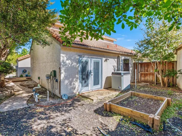 a view of a small house with a tree in the yard