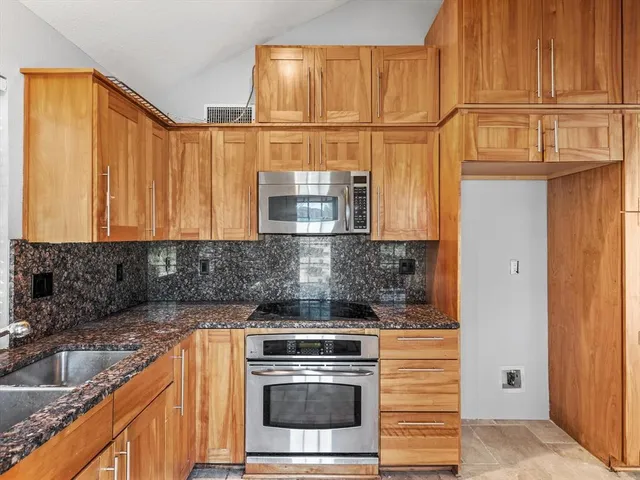 a kitchen with stainless steel appliances granite countertop a sink and a granite counter tops