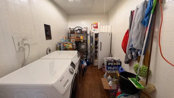 a view of a storage and utility room with two washing machine