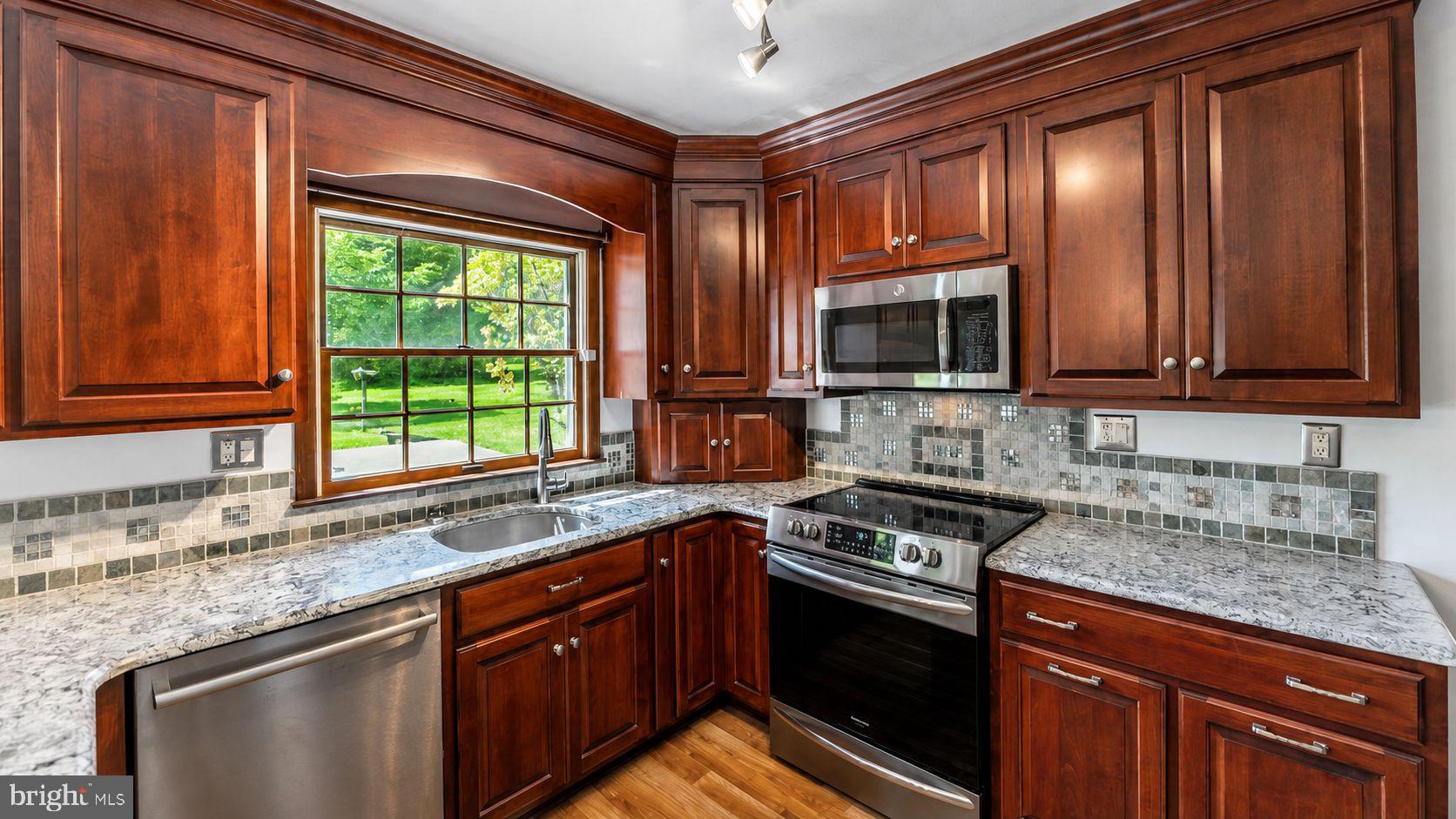 223 Trythall Road Elverson, PA 19520 - Photo 24 of 78 a kitchen with stainless steel appliances granite countertop wooden cabinets a stove and a sink