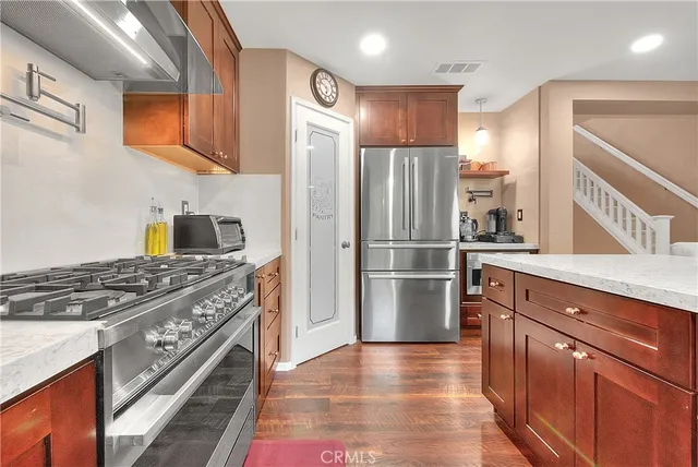 a kitchen with stainless steel appliances granite countertop a refrigerator and a stove