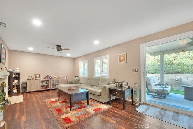 a living room with furniture a flat screen tv and a refrigerator