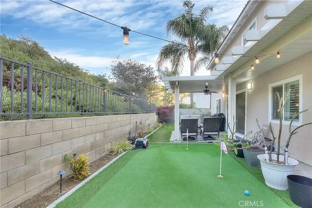 a view of a patio with table and chairs potted plants and floor to ceiling window