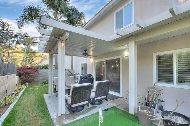 a view of a chair and table in backyard of the house