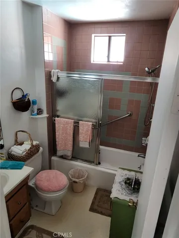 a bathroom with a granite countertop toilet sink and mirror