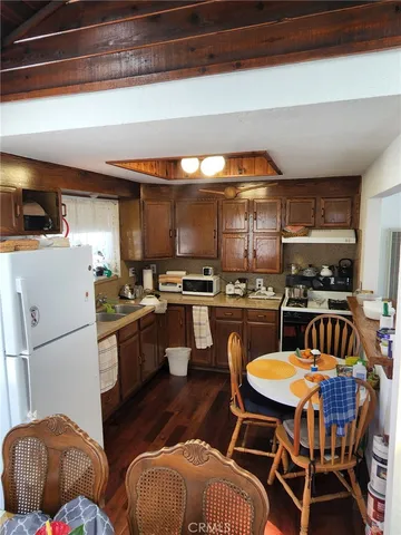 a kitchen with stainless steel appliances kitchen island granite countertop a table chairs sink and cabinets