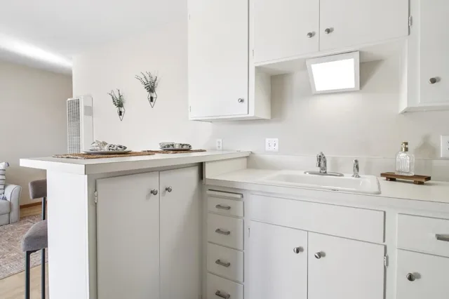 a kitchen with cabinets appliances a sink and a window