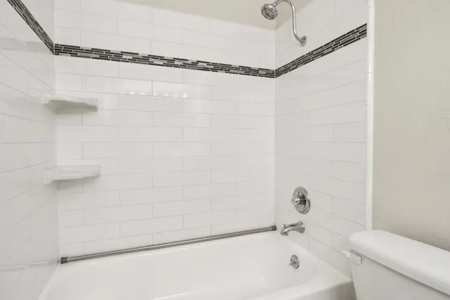 a bathroom with a granite countertop toilet and a sink