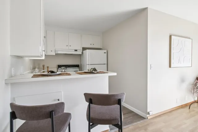 a kitchen with a chair and white cabinets