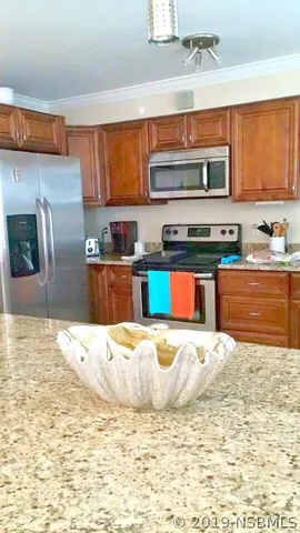 a large kitchen with granite countertop a sink stainless steel appliances and cabinets
