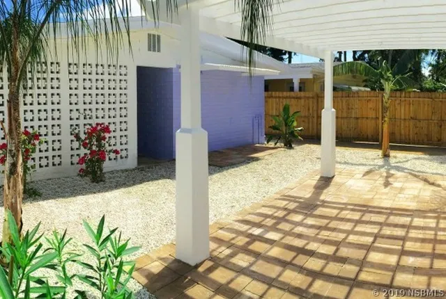 a view of a hallway with windows and chandelier