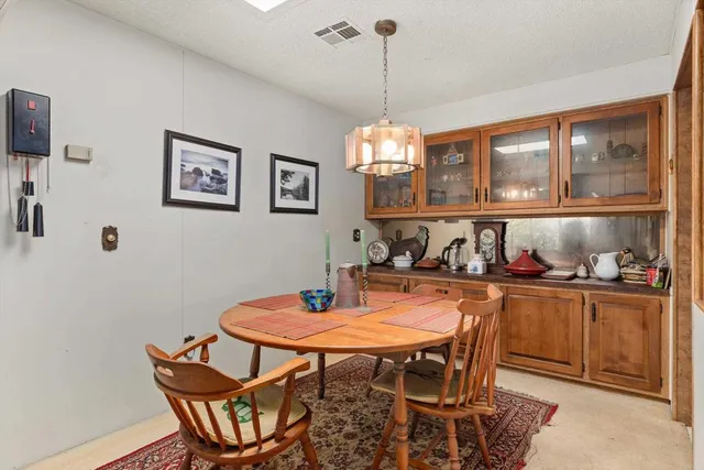 a view of a dining room and livingroom with furniture wooden floor a chandelier